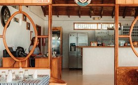 Ein einladendes Restaurant mit Holzdekor, das eine gemütliche Atmosphäre und eine offene Küche bietet.