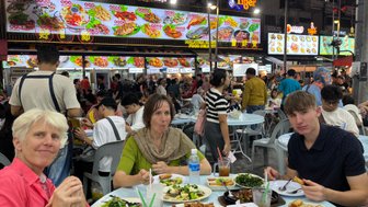 Familie genießt ein gemeinsames Abendessen in einem Restaurant in Kuala Lumpur – Malaysia & Borneo mit Kindern