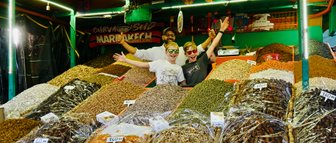 Zwei Kinder entdecken bunte Gewürze an einem traditionellen Marktstand in Marrakesch – Marokko Familienreise