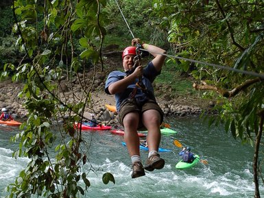 Abenteuerliche Canopy-Tour über einem Fluss mit Kajakfahrern darunter – Costa Rica Familienreise