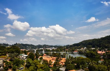 Panoramablick auf die Stadt Kandy mit grüner Landschaft und Häusern im Tal – Sri Lanka Familienreise