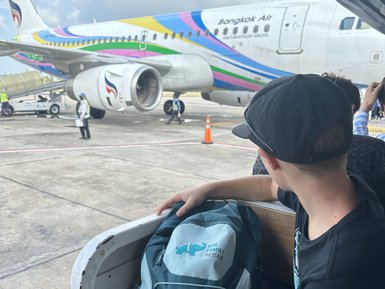 Kind mit Rucksack wartet auf Boarding ins Flugzeug - Thailand mit Kindern