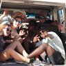 Eine Reisegruppe sitzt beisammen im offenen Kofferraum eines Jeeps - Namibia Rundreise mit Kindern