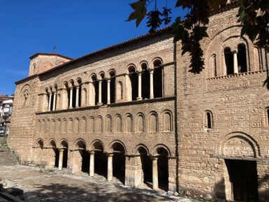 Die beeindruckende Fassade einer historischen Kirche zeigt kunstvolle Steinmetzarbeiten und Säulen unter klarem Himmel.