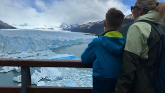 Ein Junge und eine Frau stehen an einem Geländer und betrachten den beeindruckenden Perito-Moreno-Gletscher in Argentinien.
