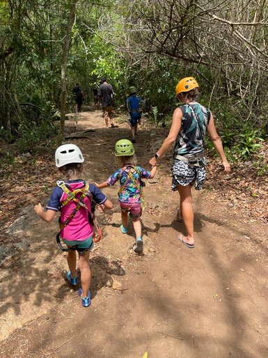 Eine Mutter spaziert mit ihren Kindern auf einem Waldpfad durch den Punta Laguna Park – Mexiko mit Kindern