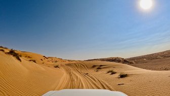 Geländewagen in der Wahiba-Wüste mit Sonnenlicht – Oman Familienreise