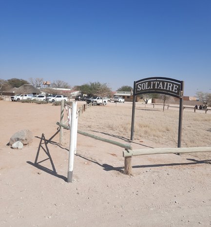 Ein schlichtes Ortsschild markiert den Eingang zum Dorf Solitaire - Namibia mit Kindern
