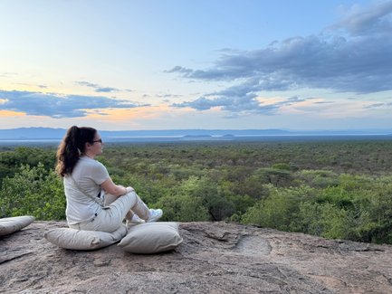 Teenagerin sitzt mit Aussicht auf die Savanne im Tarangire-Nationalpark – Tansania mit Kindern