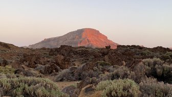 Der majestätische Teide erhebt sich über die karge Landschaft, beleuchtet von sanften Abendlichtern.
