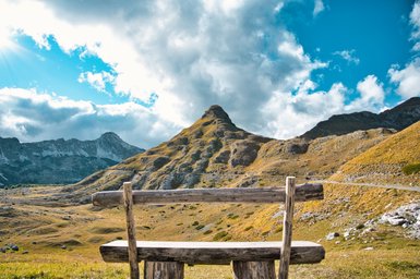 Eine einsame Bank steht alleine in der Natur mit einem traumhaften Blick in die Ferne
