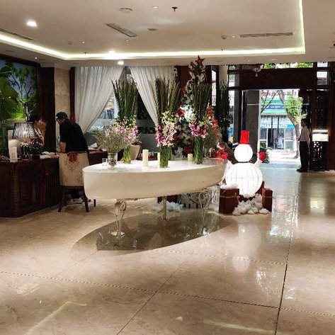 Der Empfangsbereich des Hotels ist elegant mit Blumenarrangements und einem freundlichen Empfangspersonal gestaltet.