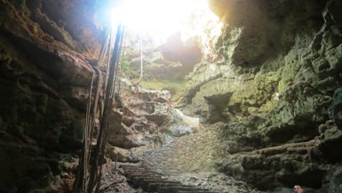 Sonnenstrahlen fallen durch eine Öffnung in die Höhle von Loltún – Mexiko mit Kindern