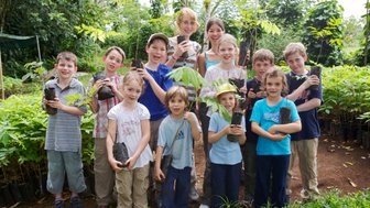 Gruppe von Kindern mit Mini-Bäumen zum Pflanzen – Costa Rica mit Kindern