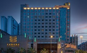 Das Tianfu Sunshine Hotel erstrahlt in der Dämmerung, umgeben von modernen Gebäuden und beleuchteten Straßenlaternen.