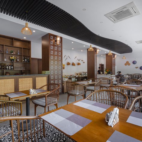 Ein modernes Restaurant mit stilvollen Holzmöbeln und einer gut sortierten Bar im Hintergrund, das einladend wirkt.