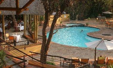 Ein einladender Poolbereich umgeben von Bäumen und Sonnenliegen, ideal für Entspannung und Erholung im Freien.