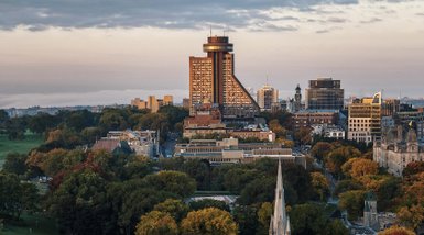 Der Blick auf die Stadt zeigt das markante Hotel Le Concorde, umgeben von bunten Herbstbäumen und modernen Gebäuden.