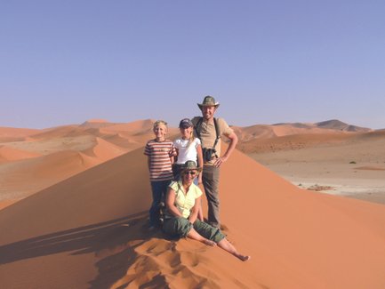 Eine Familie steht auf einer Sanddüne - Namibia mit Kindern