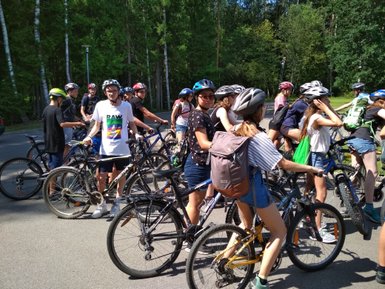 Eine Gruppe von Jugendlichen steht auf ihren Fahrrädern, bereit für eine Radtour in der Natur.
