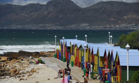 Farbenfrohe Strandhäuschen und badende Familien am St James Beach bei Kapstadt – Garden Route mit Kindern