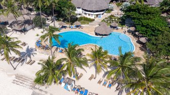 Ein tropisches Resort mit einem glitzernden Pool, umgeben von Palmen und Sonnenliegen am weißen Sandstrand.