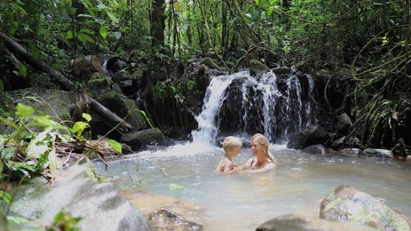 Mutter und Kind genießen das Baden im natürlichen Wasserbecken in La Tigra – Costa Rica Familienreise