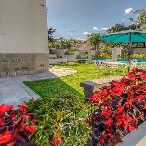 Ein gepflegter Garten mit bunten Blumen und einem grünen Rasen, ideal für Entspannung und Freizeitaktivitäten.