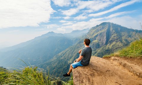 Junge macht eine Pause auf einem Felsen am Little Adam’s Peak Wanderweg in Ella – Sri Lanka Reise mit Kindern