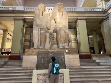 Jugendliche steht vor einer altägyptischen Statue im Museum in Kairo  - Ägypten Reise mit Kindern