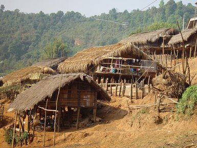 traditionelle Huetten am Hang auf Stelzen mit Strohdach im Dorf Doi Ang Khang, Chiang Mai - Thailand Reise mit Kindern