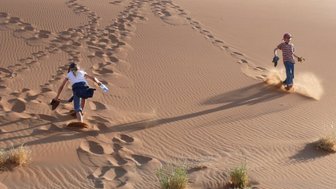 Zwei Kinder spielen auf einer Sanddüne - Namibia Rundreise mit Kindern