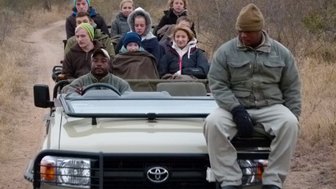 Offener Jeep mit neugieriger Reisegruppe auf Pirschfahrt durch die südafrikanische Wildnis – Südafrika Familienreise