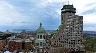 Die beeindruckende Architektur des Hotel Le Concorde in Quebec, umgeben von historischen Gebäuden und einer malerischen Landschaft.