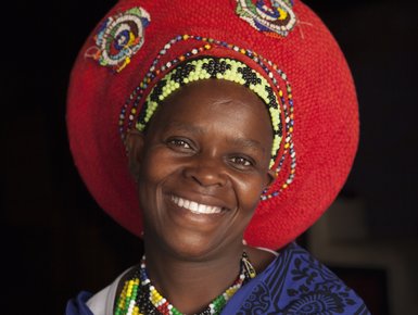 Südafrikanische Frau trägt farbenfrohe, traditionelle Kleidung – Südafrika mit Kindern