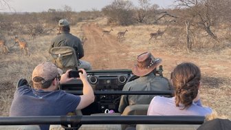 Reisegruppe auf Safari im offenen Jeep bei einer Pirschfahrt im Kruger Nationalpark – Südafrika mit Kindern