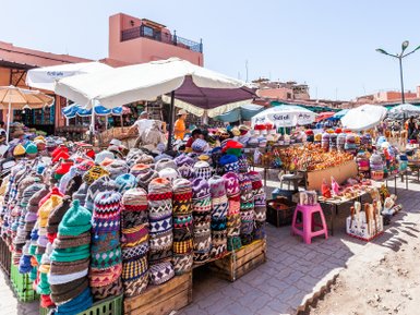 Farbenfrohe Marktstände mit vielfältigen Waren auf dem Djemaa el Fna Platz in Marrakesch – Marokko Reise mit Kindern