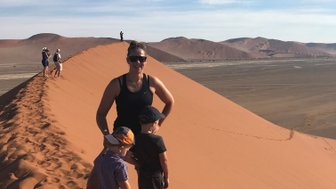 Eine Mutter steht mit zwei Kindern auf einer Sanddüne - Namibia Rundreise mit Kindern