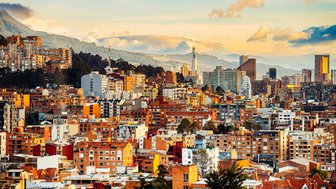 Die Stadt Bogotá zeigt eine beeindruckende Skyline mit modernen Gebäuden und einer malerischen Bergkulisse im Hintergrund.