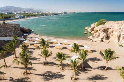 Strand des Crowne Plaza Muscat mit Liegestühlen und Sonnenschirmen – Familienurlaub in Muscat