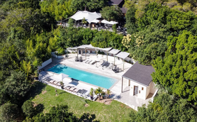 Ein luftiger Blick auf einen einladenden Pool, umgeben von üppigem Grün und modernen Liegen, ideal für Entspannung.