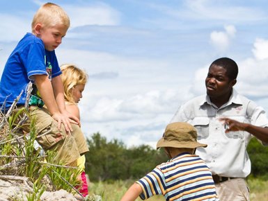 Ein Guide erklärt drei Kindern etwas - Namibia Rundreise mit Kindern