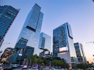 Hochmoderne Wolkenkratzer erheben sich majestätisch gegen den Abendhimmel in Gangnam, Seoul, umgeben von urbanem Leben.