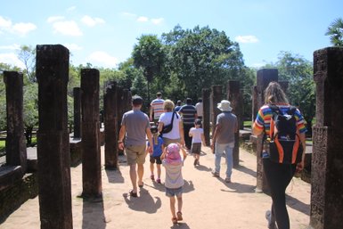 Familie erkundet die Ruinenstadt Polonnaruwa und steht zwischen Steinsäulen – Sri Lanka Reise mit Kindern