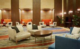 Ein eleganter Foyerbereich mit modernen Möbeln, der eine einladende Atmosphäre mit warmen Farben und stilvollen Akzenten schafft.