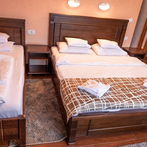 Ein gemütliches Schlafzimmer mit zwei Betten, einem Nachttisch und einem weichen Teppichboden, ideal für Entspannung.