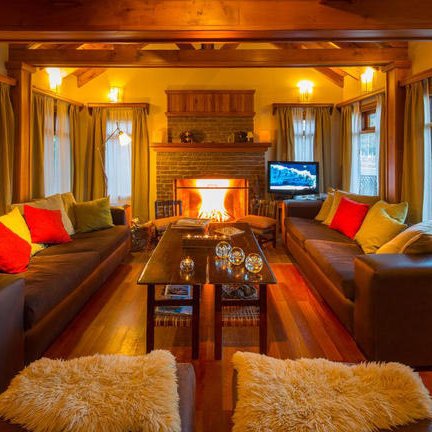 Ein gemütliches Wohnzimmer mit zwei großen Sofas, einem Kamin und warmem Licht, das eine einladende Atmosphäre schafft.