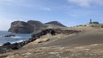 Eine beeindruckende Küstenlandschaft mit schroffen Klippen und einem Leuchtturm, der über das ruhige Meer wacht.