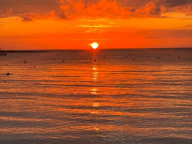 Farbenfroher Sonnenuntergang über dem Strand mit sanften Wellen – Mexiko mit Kindern