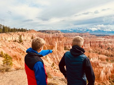 Zwei Jungen stehen am Rand des Bryce Canyon und betrachten die beeindruckenden Felsformationen in der Ferne.